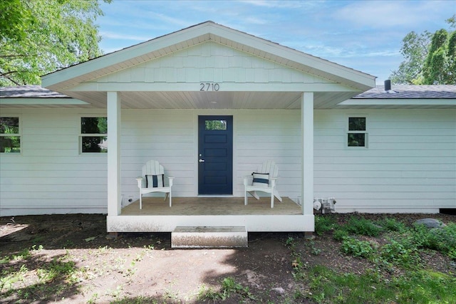 view of exterior entry featuring covered porch