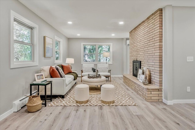 living room featuring baseboards, wood finished floors, and a healthy amount of sunlight