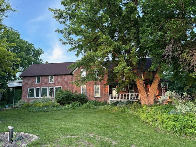 view of front of house with brick siding and a front lawn