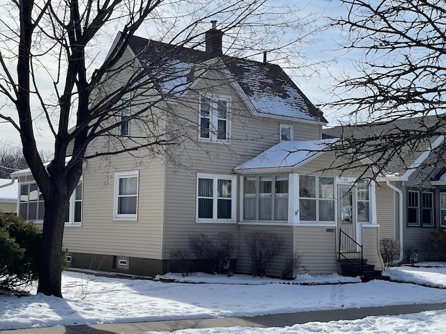 exterior space featuring entry steps, a sunroom, and a chimney