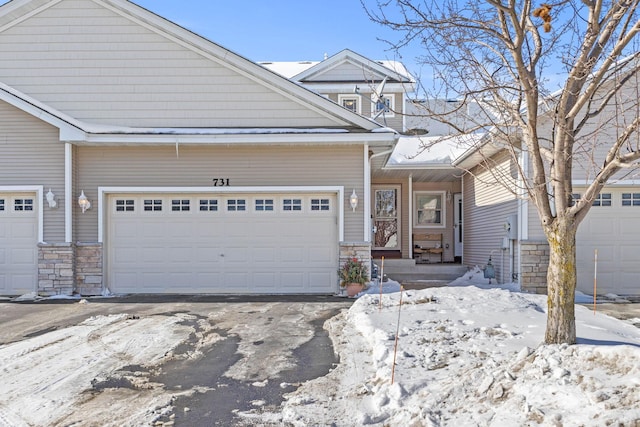 view of front of property featuring stone siding and driveway