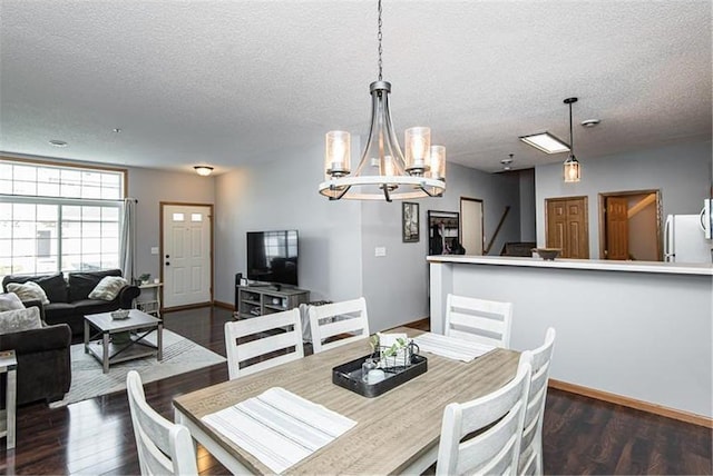 dining room featuring dark wood-type flooring and a textured ceiling