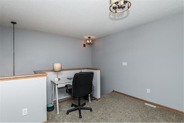 carpeted office space featuring a textured ceiling