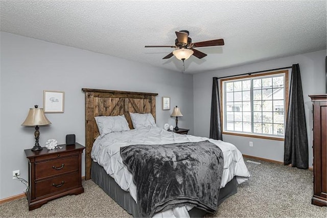 bedroom featuring a textured ceiling, light colored carpet, and ceiling fan