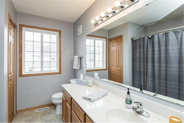 bathroom with a shower with shower curtain, vanity, and toilet