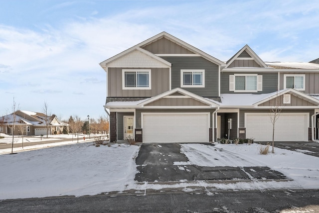 view of front facade featuring board and batten siding, an attached garage, and aphalt driveway