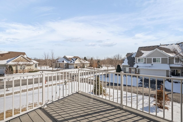 snow covered deck featuring a residential view