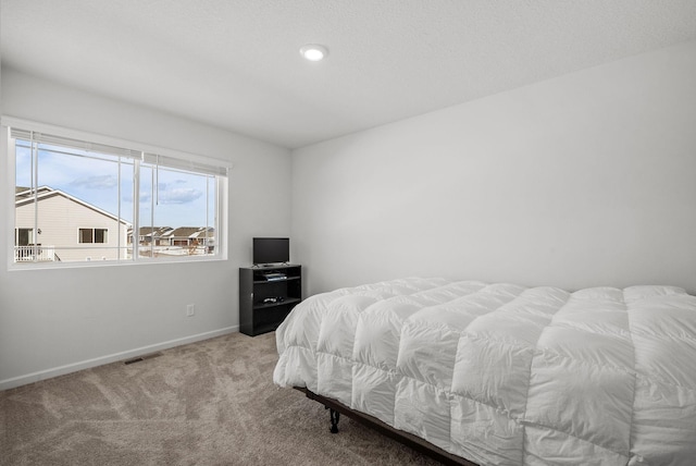 carpeted bedroom featuring visible vents and baseboards