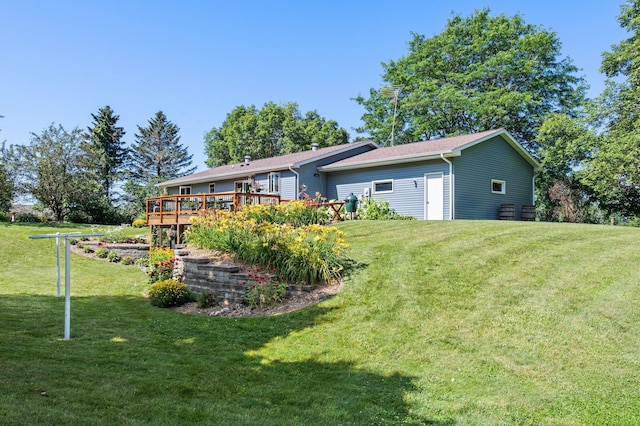 back of property with a lawn and a wooden deck