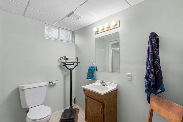 bathroom with toilet, a drop ceiling, vanity, and visible vents