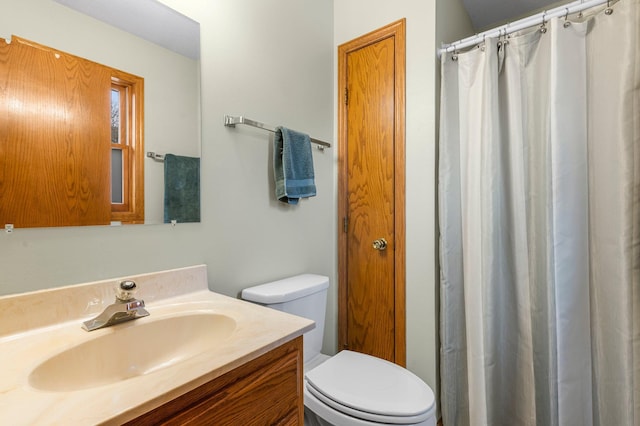 bathroom with toilet, curtained shower, and vanity