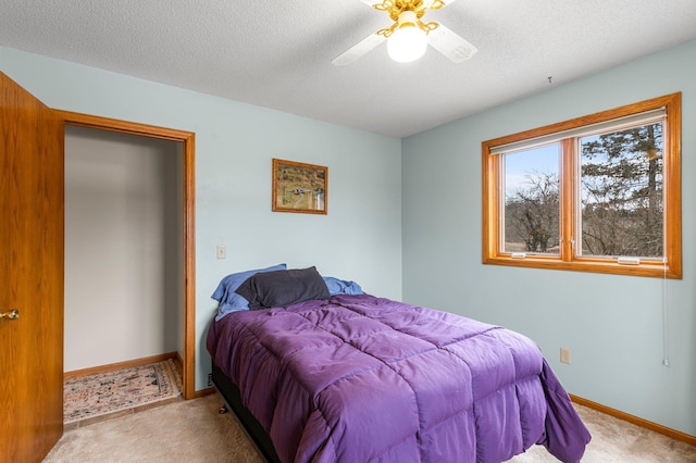 bedroom with a ceiling fan, carpet, a textured ceiling, and baseboards