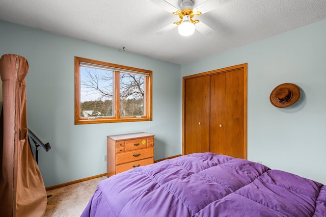 bedroom with carpet, a closet, a textured ceiling, and baseboards