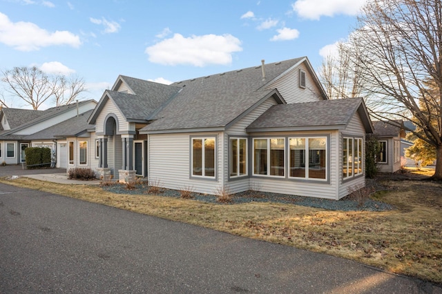 view of front of house with a shingled roof, driveway, and a garage