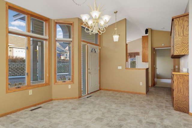 interior space with a healthy amount of sunlight, vaulted ceiling, visible vents, and an inviting chandelier