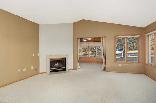 unfurnished living room featuring carpet floors, a high end fireplace, vaulted ceiling, and baseboards