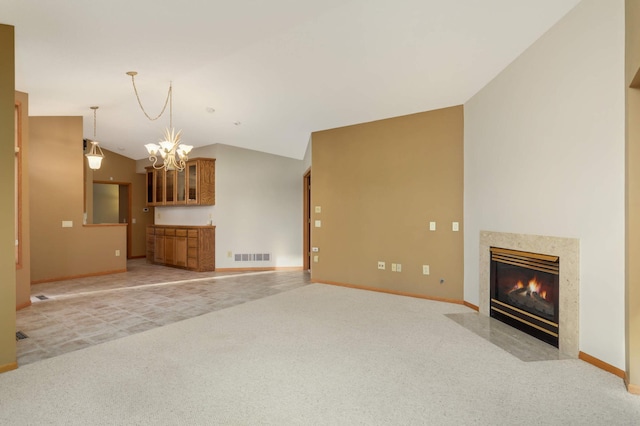 unfurnished living room with light carpet, baseboards, lofted ceiling, an inviting chandelier, and a high end fireplace