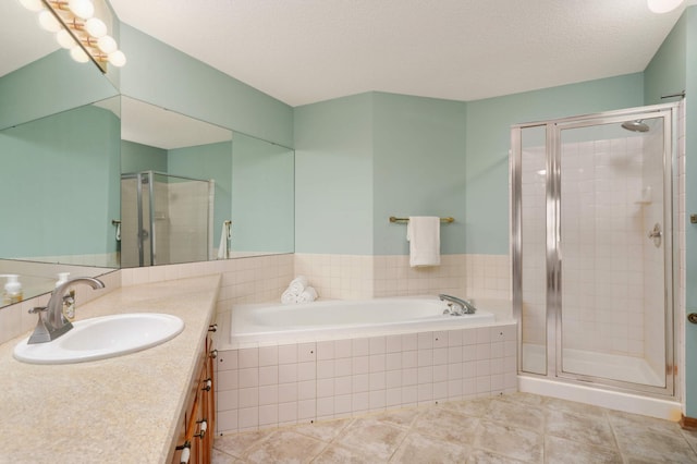 bathroom with a garden tub, a stall shower, a textured ceiling, vanity, and tile patterned flooring