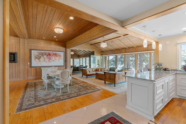 dining area featuring wooden walls, wood ceiling, light tile patterned flooring, beam ceiling, and recessed lighting