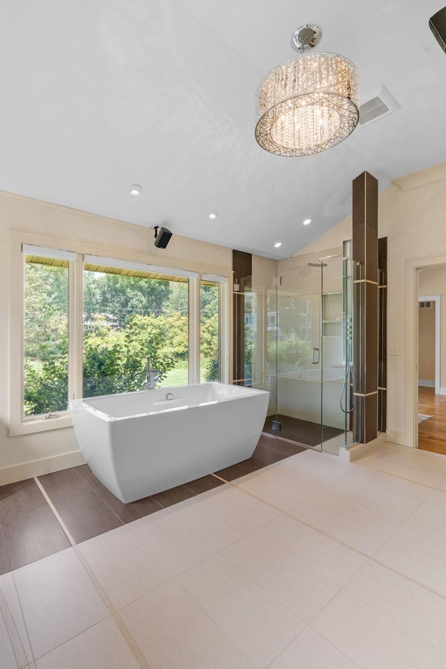 bathroom with a freestanding tub, recessed lighting, vaulted ceiling, a stall shower, and an inviting chandelier