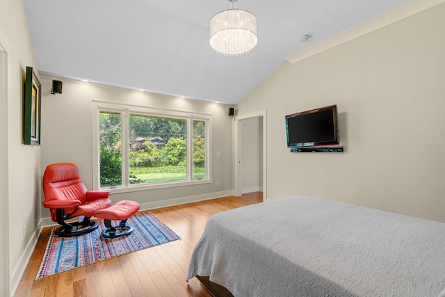 bedroom with lofted ceiling, an inviting chandelier, baseboards, and wood finished floors