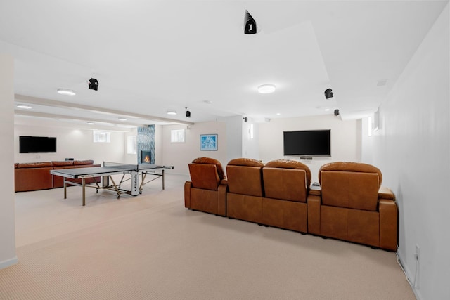 home theater room with a large fireplace and carpet flooring