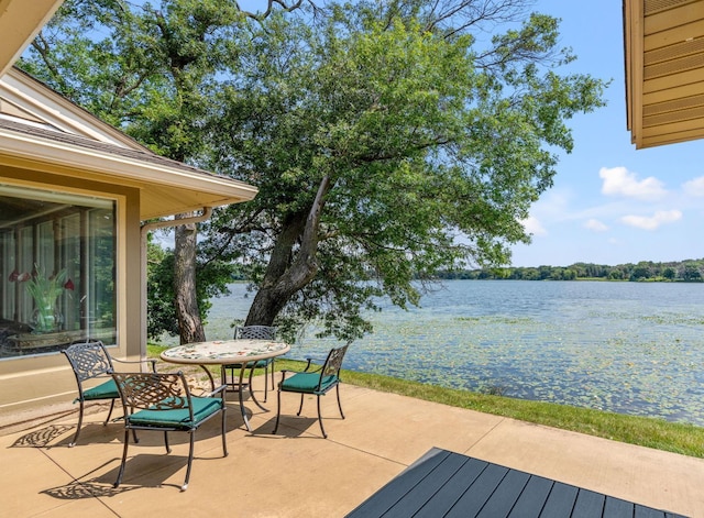 wooden deck featuring a patio area, outdoor dining area, and a water view