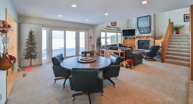 dining area with stairs, a fireplace, light carpet, and recessed lighting