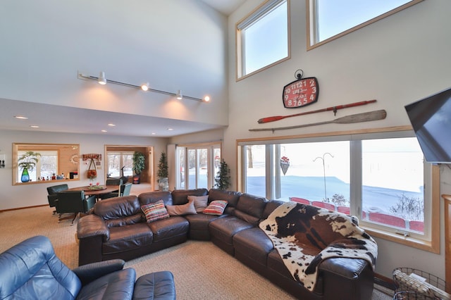 living area featuring a high ceiling, recessed lighting, carpet flooring, and baseboards