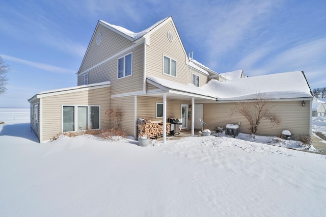 snow covered house with central AC unit