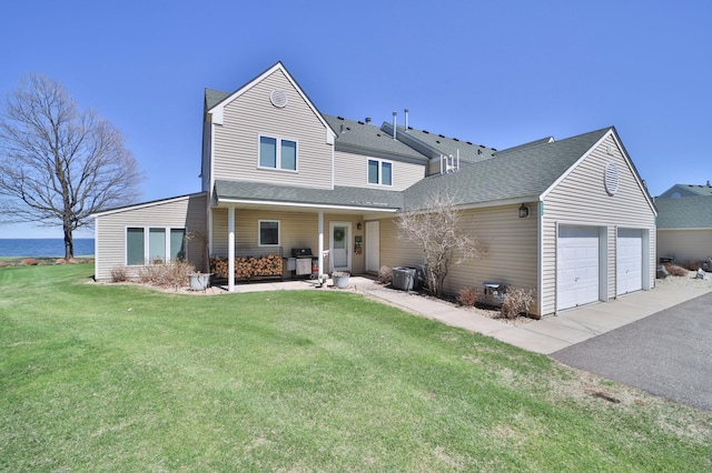 7968 Tournament Trl, Onamia, MN 56359 - traditional-style house featuring an attached garage, a front lawn, roof with shingles, and cooling unit