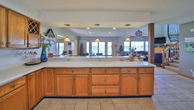 7968 Tournament Trl, Onamia, MN 56359 - kitchen with light countertops, a peninsula, light tile patterned floors, and brown cabinets
