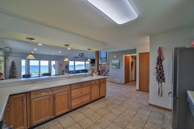 7968 Tournament Trl, Onamia, MN 56359 - kitchen with light countertops, hanging light fixtures, freestanding refrigerator, and brown cabinets
