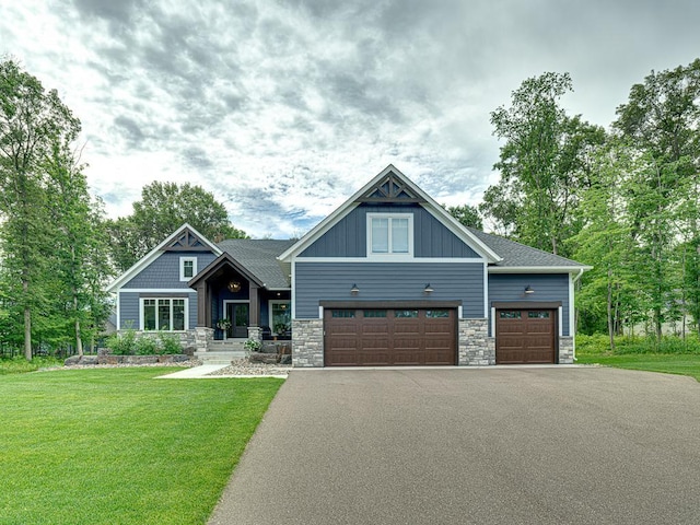 craftsman inspired home with a garage and a front lawn