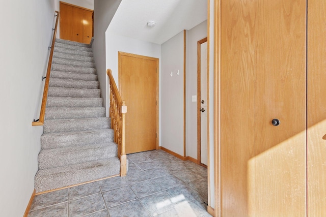 stairs with tile patterned floors and baseboards