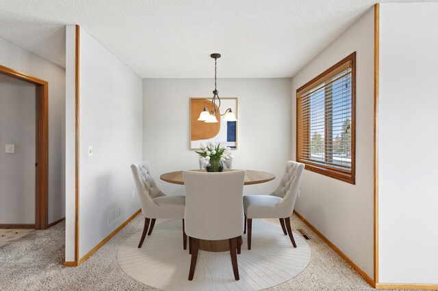 dining area featuring visible vents, light carpet, baseboards, and a chandelier