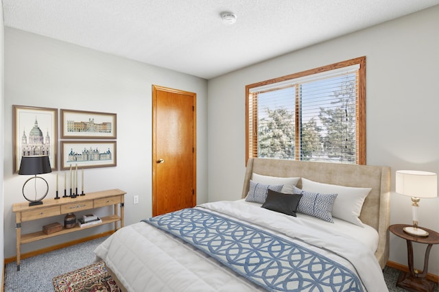 bedroom with a textured ceiling, baseboards, and carpet floors