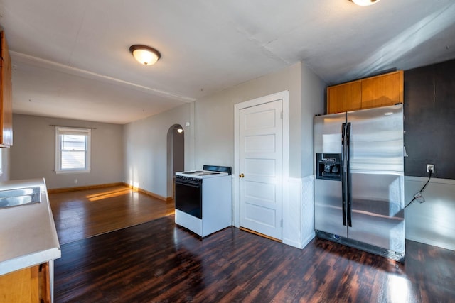 kitchen featuring white range with electric cooktop, dark hardwood / wood-style floors, and stainless steel fridge with ice dispenser