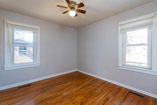 unfurnished room with hardwood / wood-style floors, a wealth of natural light, and ceiling fan