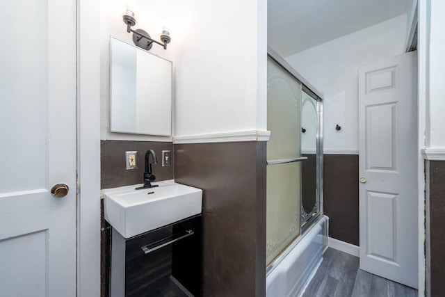 bathroom with vanity, hardwood / wood-style flooring, and combined bath / shower with glass door