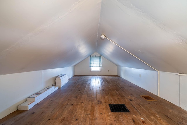 additional living space featuring lofted ceiling and dark hardwood / wood-style floors