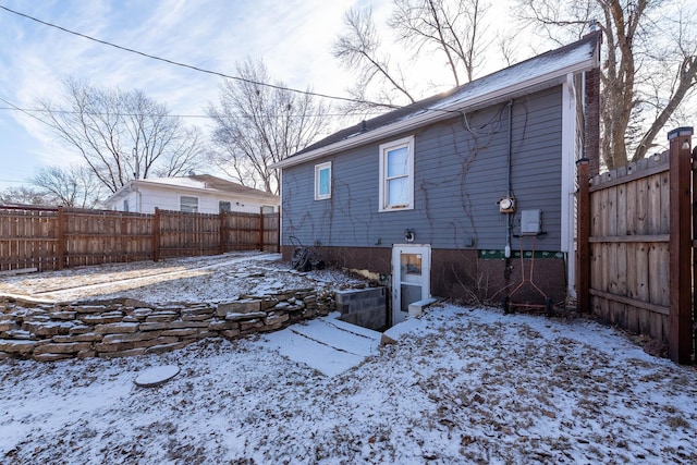 view of snow covered rear of property