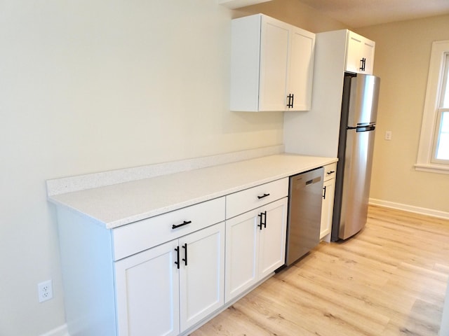 kitchen featuring light wood-type flooring, white cabinetry, and stainless steel appliances