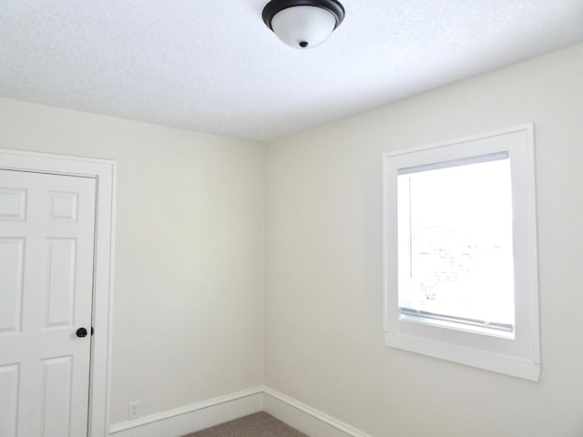 spare room with a textured ceiling