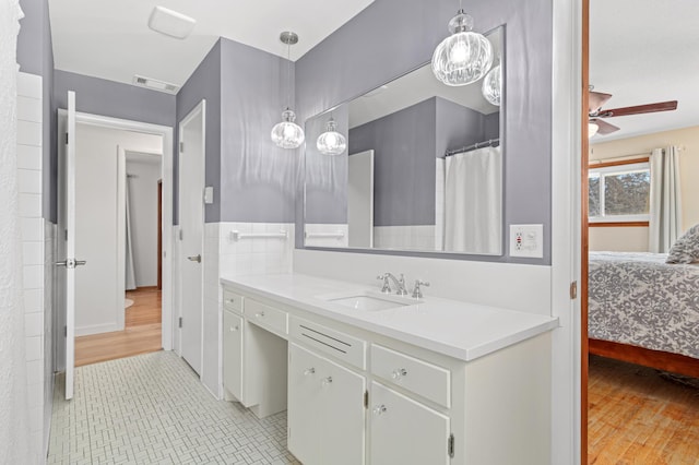 ensuite bathroom featuring wood finished floors, vanity, visible vents, a ceiling fan, and ensuite bath