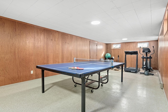 recreation room featuring a baseboard heating unit and wooden walls