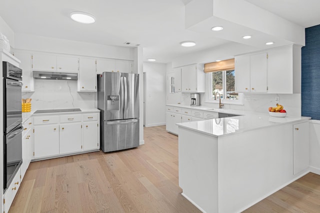 kitchen with black electric stovetop, under cabinet range hood, white cabinets, light countertops, and stainless steel fridge with ice dispenser