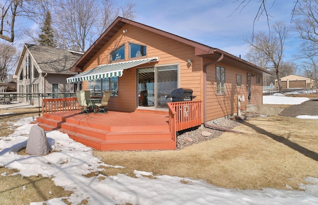 snow covered house featuring a deck