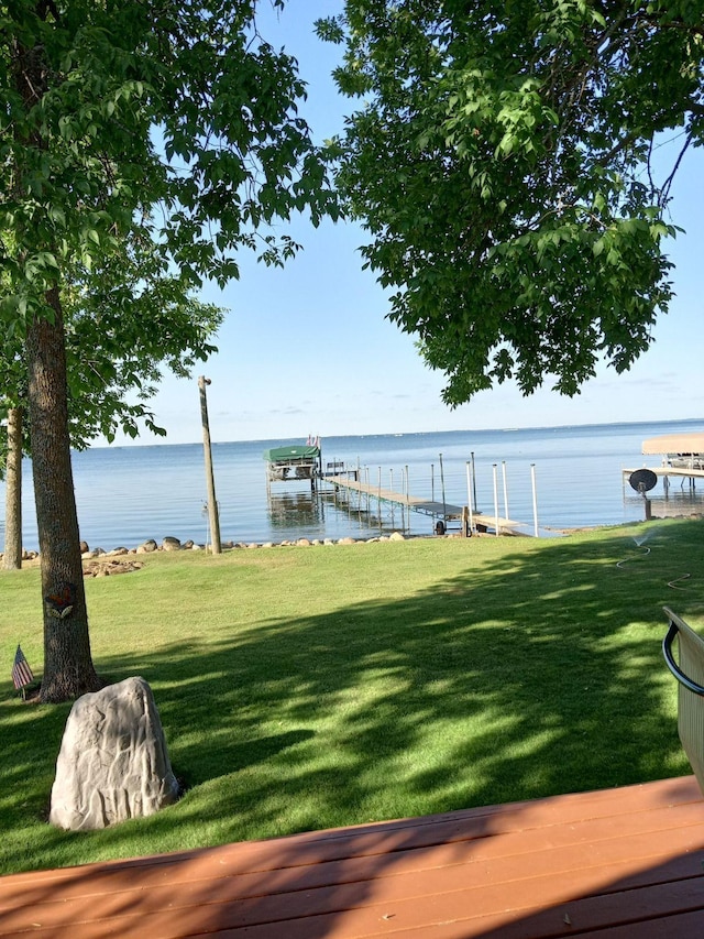 view of dock featuring a water view and a yard