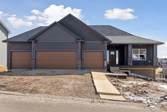 craftsman inspired home with stone siding, a garage, and roof with shingles